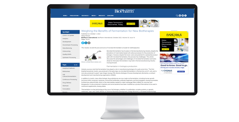 A computer screen displays a BioPharm International article titled “Weighing the Benefits of Fermentation for New Biotherapies,” highlighting industry insights.